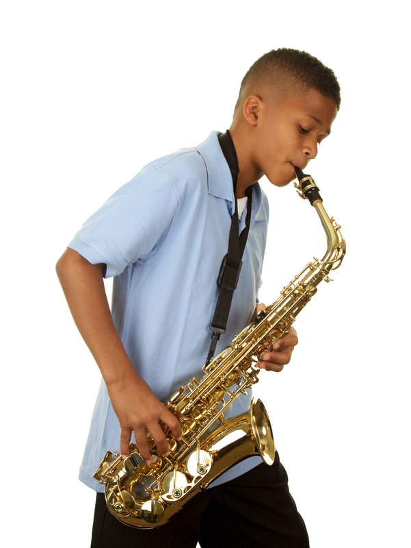 Boy playing the saxophone after learning to play from online music lessons