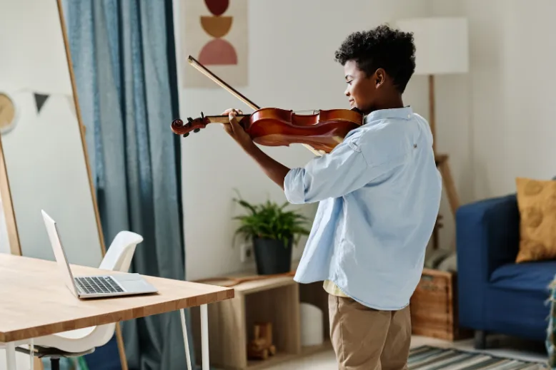 child engaged in an online music lesson