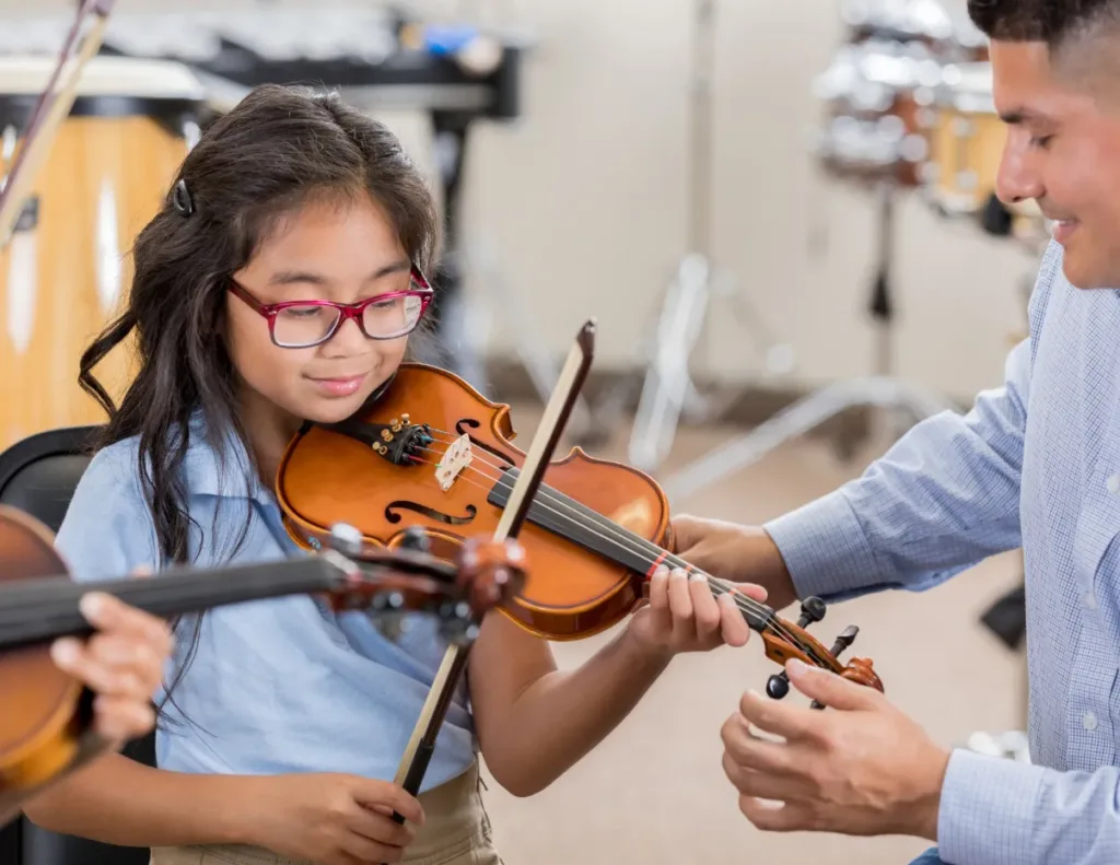 teacher providing one-on-one feedback to a student during a group music lessons.